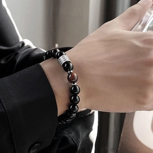 Dettaglio del bracciale da uomo con perle in occhio di tigre e ossidiana al polso