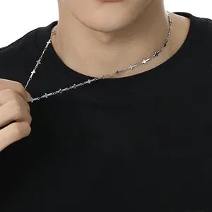 Dettaglio della collana a maglie incrociate argento con micro elementi a croce su un uomo