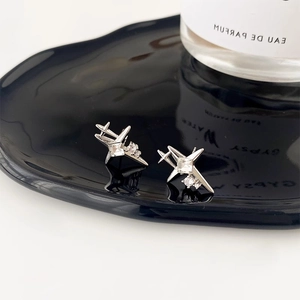 Minimalist silver star stud earrings with sparkling crystals on a sleek black display