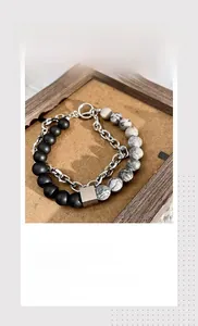 Detail of double-layer natural stone bracelet with matte black beads and silver chain