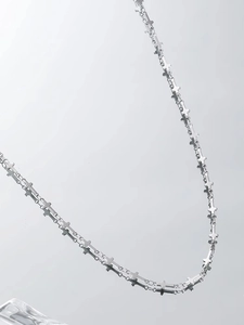 Vista macro di una collana a catena con maglie a croce argento dal design gotico