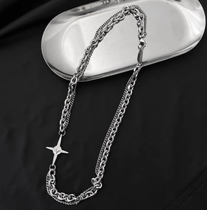 Collier double chaîne argenté avec pendentif étoile polaire sur fond de soie noire