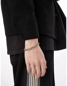 Close-up of dual-tone gold and silver Cuban link bracelet on a model wrist