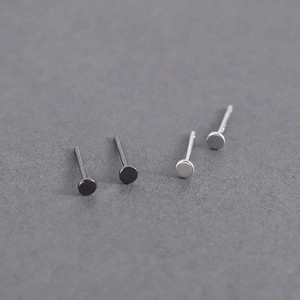 Detailed view of minimalist black and silver round stud earrings for men