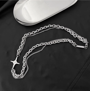 Détail du collier à double chaîne argentée avec un pendentif étoile en zircon