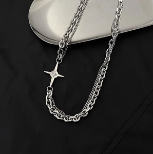 Gros plan d'un collier double épaisseur en argent avec pendentif étoile sur fond noir