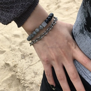 Double-layer natural stone beaded bracelet with silver metal chain on beach background