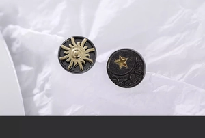 Detailaufnahme der Retro-Ohrstecker mit goldenem Sonnen- und Monddesign auf schwarzem Grund