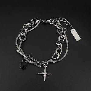 Detail eines zweilagigen Punk-Armbands mit Sternanhänger und schwarzem Edelstein-Inlay