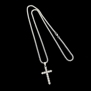 Detailed view of silver cross pendant with sparkling zircons and heavy link chain