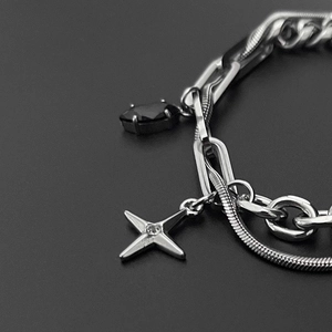 Nahaufnahme des mehrlagigen Titanstahl-Armbands mit schwarzem Stein und Sternanhänger