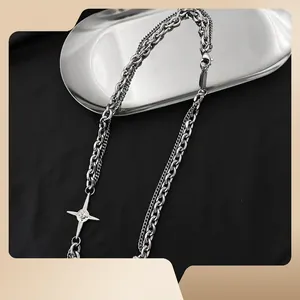 Collier double couche argenté avec pendentif étoile à quatre branches sur fond noir