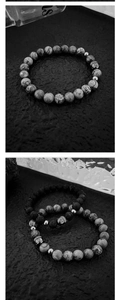 Makroaufnahme von Vulkansteinperlen und silbernem Buddhakopf-Detail auf dem Armband