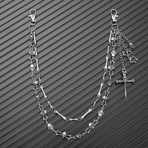 Detail view of multi-layered silver skull and cross pendants on punk hip-hop wallet chains