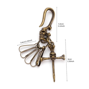 Detailed view of vintage brass skull keychain with dimensions and rustic metal carving