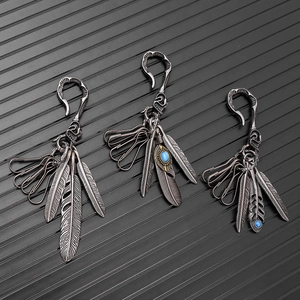 Detailed view of vintage turquoise feather pendants with intricate silver alloy carvings