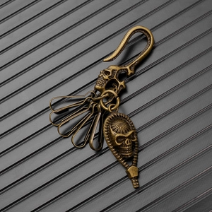Macro detail of vintage brass skull keychain featuring rustic finish and metal key clips