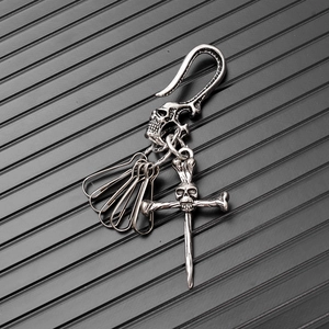 Detail of vintage punk skull keychain with embossed hook and silver bone pendants