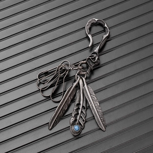 Close-up of vintage silver feather keychain with turquoise stone and eagle hook detail