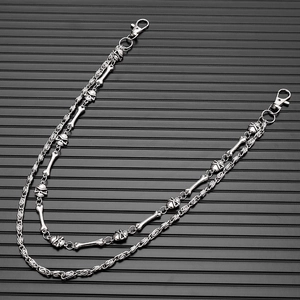 Detail of double-layered punk skull waist chain with lobster clasps on black background