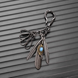 Detail of vintage silver feather keychain with turquoise stone and utility metal hooks