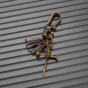 Detail of vintage bronze skull and crossbones keychain with hooks and rings