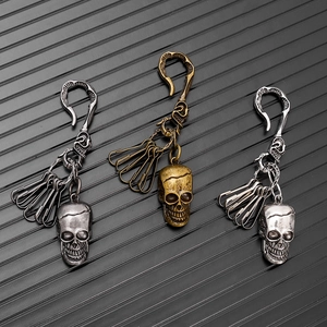 Detailed view of three vintage skull keychains in bronze and silver-gray alloy finishes
