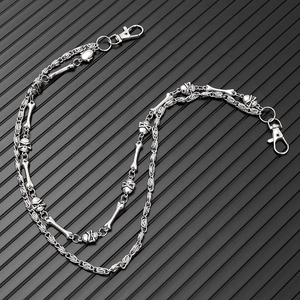 Detail of silver double-layered punk waist chain featuring metal skull and bone charms