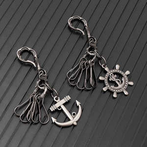 Detail of vintage anchor and helm pendants with skull hook on a rustic silver keychain