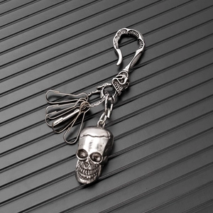 Detail of punk skull keychain with vintage silver matte finish and metal clip rings