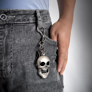 Vintage silver skull keychain accessory on denim jeans for punk and hip-hop style