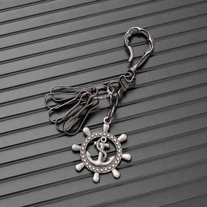 Macro detail of vintage anchor and helm charms on a punk style metallic keychain