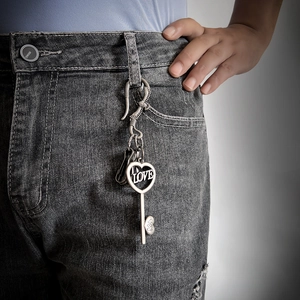 Vintage silver heart key keychain with Love engraving hanging on denim jeans belt loop