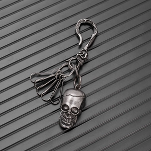 Macro shot of retro metal skull keychain with antique silver finish and safety pins