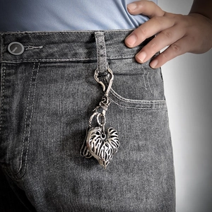 Retro punk heart and skull pendant keychain accessory styled on grey denim jeans