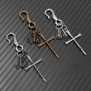 Macro shot of gothic punk cross keychains with skull details in bronze, silver, and black