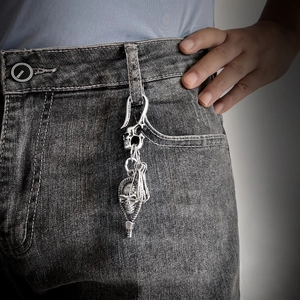 Vintage punk skull keychain in silver metal hanging on denim jeans belt loop
