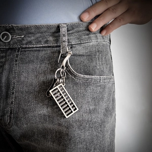 Vintage silver abacus keychain pendant accessory shown on denim jeans belt loop