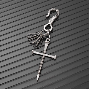 Detail of punk style key chain with vintage silver skull cross and decorative S-hook