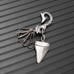 Macro view of vintage silver shark tooth pendant with fishtook and multi-function clips
