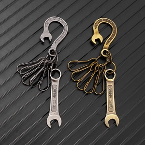 Detail of vintage wrench keychain pendants in antique silver and bronze for workwear pants