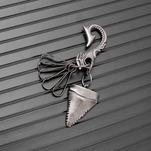 Macro view of vintage silver shark tooth pendant with decorative clips on textured metal chain