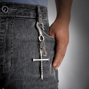 Gothic skull cross keychain pendant on denim jeans with vintage metallic finish
