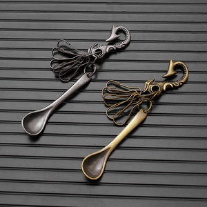Detail of hip hop spoon pendants with vintage silver and bronze finish on hook keychain