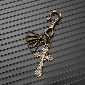 Dettaglio macro del ciondolo croce in bronzo vintage con incisione INRI su sfondo rigato