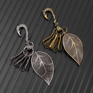 Detail of vintage leaf pendants on punk style metal keychains in silver and bronze finish