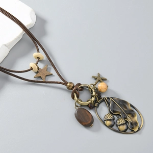 Détail du collier ethnique vintage avec pendentif feuille en bronze et perles en bois