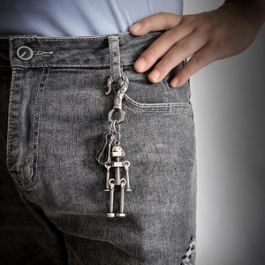 Portachiavi vintage a forma di robot in metallo argentato appeso ai jeans blu