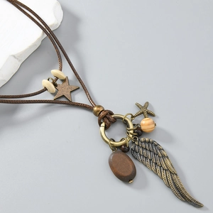 Close-up of vintage feather and starfish pendants on a layered brown leather necklace