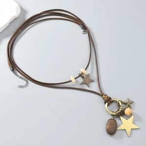 Detail einer mehrlagigen braunen Kordelkette mit goldenen Sternen und Holzperlen-Anhängern